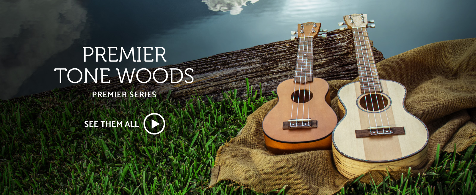 two Hilo Premier Tone Woods ukuleles lying on grass beside wood plank